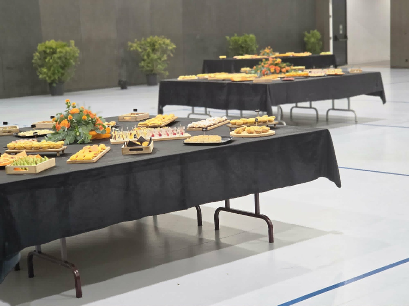 Montagem de várias mesas de catering num espaço de eventos